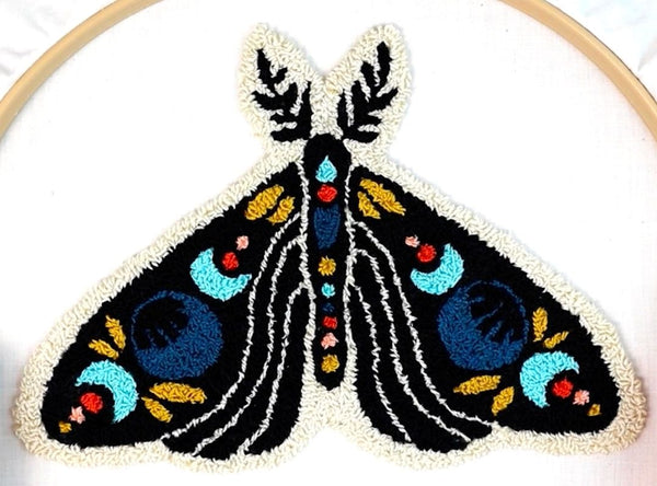 photo of finished celestial moth punch needle design still in the embroidery hoop