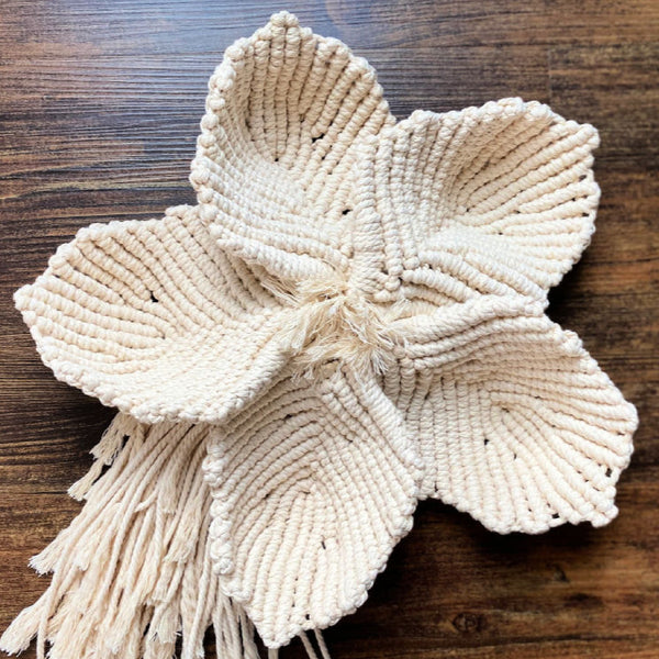 large macrame flower on a wood floor
