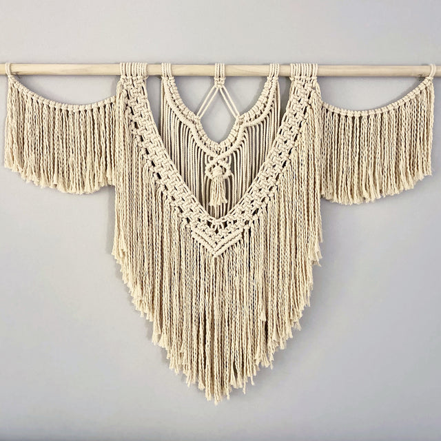 finished large macrame wall hanging on a light gray wall