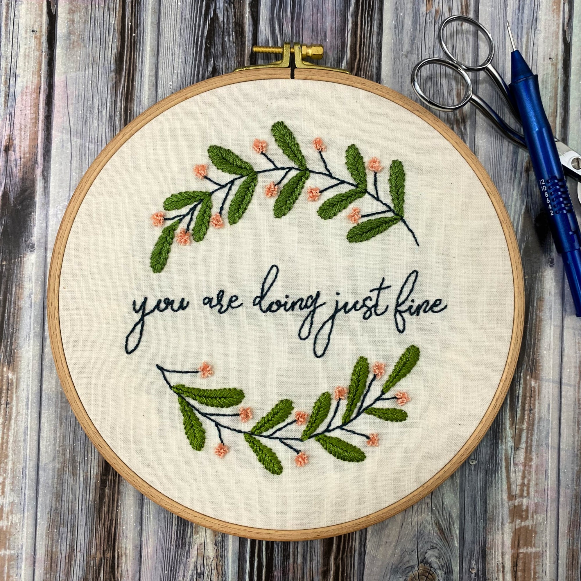 embroidery hoop with you are doing just fine wall art and an Ultra Punch needle sitting on a table