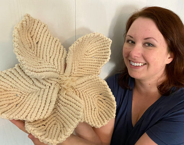 Crystal from Marching North holding up a large macrame flower