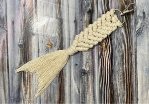 finished macrame mermaid tail keychain laying on a wooden table