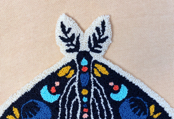 up close shot of the top of celestial moth punch needle embroidery design